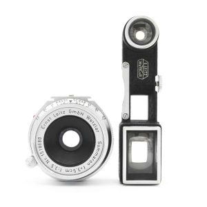 -Dieses Leitz Leica-M Summaron 3.5cm / 3.5 (SOONC-MW/SOMWO / 11107) mit der No.1518680 wurde im Juli 2026 revidiert. Das Objektivbajonett und der nicht rotierende Tubus zeigen nur wenig Gebrauchsspuren. Die Optik hat einen Distanzanzeige in Meter, der Distanzeinstellring dreht fein. Die typische Trübung des M-Summaron, eines symmetrischen Gauss Aufbaus mit 6 Linsen bei dem die mittleren 4 Linsen in Paaren miteinander verkittet sind, wurde anlässlich der Revision entfernt. von clean-cameras