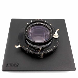 Voigtländer Braunschweig Technica-Heliar 4.5 / 21cm Die Linsen des Technika Heliar sind in einem sehr schönen Zustand. Das Objektiv wurde im Juni 2026 revidiert. Die Linsen sind klar und haben keine Kratzer, Fungus oder Separation. Dieses Heliar wurde 1958 hergestellt: Es besitzt die hochentwickelte Nachkriegs-Einschichtvergütung erkennbar ist dies auch an dem wunderschön bläulich-violetten Schimmer der Frontlinse. Diese sorgt bei Porträts für deutlich bessere Kontraste und weniger Streulichtanfälligkeit im Vergleich zu den unvergüteten Vorkriegs-Heliars. von clean-cameras