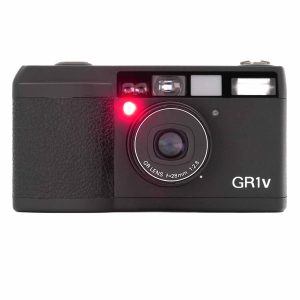 Ricoh GR1v -Diese Ricoh GR1v (No.531102667) befindet sich in einem sehr guten Zustand. Das Gehäuse hat keine Gebrauchsspuren. Der Motor transportiert den Film einwandfrei. Eine Besonderheit dieses Ricoh-Modells: Zunächst wird der Film durch den Motor automatisch aus der Kassette abgewickelt. Nach der Auslösung werden die Bilder dann einzeln in die Kassette eingezogen. So sind die Bilder in der Kassette geschützt, falls die Kamera versehentlich geöffnet wird. von clean-cameras