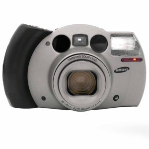 Die angeboten Samsung ECX1S (No.8504654) ist in einem sehr guten Zustand. Das Gehäuse hat nur wenig Gebrauchsspuren. Die Displayabdeckung hat keine Kratzer. Das Samsung Zoom Lens Optik 38-140 mm 3.9-11 fährt ohne Ruckler aus und ein. Dies Linsen sind klar, es hat keine Vergütungsschäden.